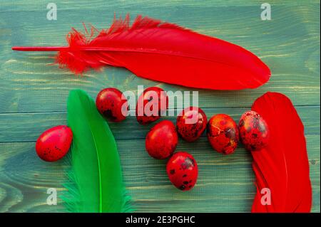 Macro photo of red easter quail egg. Painted red quail eggs on a green wood background. Easter Stock Photo