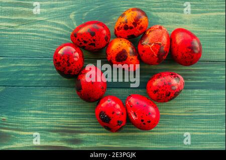 Macro photo of red easter quail egg. Painted red quail eggs on a green wood background. Easter Stock Photo