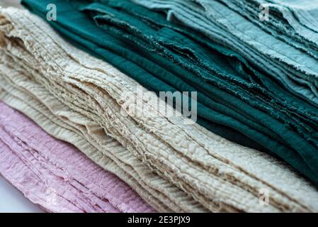 Creased, crinkled cotton cuts are stacked obliquely. Textile striped backgrounds. Stock Photo