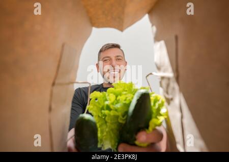 Man taking products from grocery bag. Home delivery during COVID-19. Stock Photo
