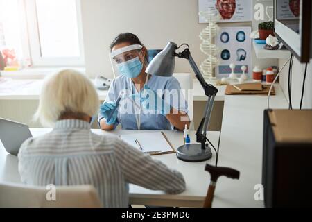 General practitioner explaining the using of a pen injector device Stock Photo