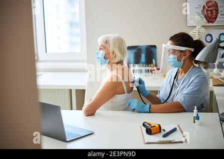 Medical specialist listening to a retired female breathing Stock Photo
