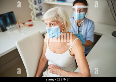 Unhappy retired person undergoing a lung check Stock Photo