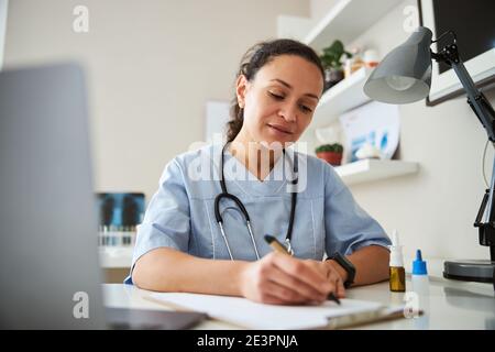 Physician writing in a notepad with an eco-pen Stock Photo