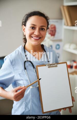 Glad doctor attracting attention to a notepad page Stock Photo