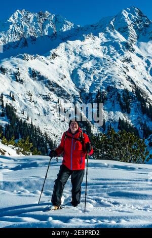 Schneeschuhläufer auf dem Sonnenkopf, mit Aussicht auf die Berge des Montafon. snowshoe hiker on the mountain of silver valley. beautiful landscape Stock Photo
