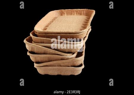 Biodegradable food trays made from pressed cardboard isolated on black background. Closeup Stock Photo