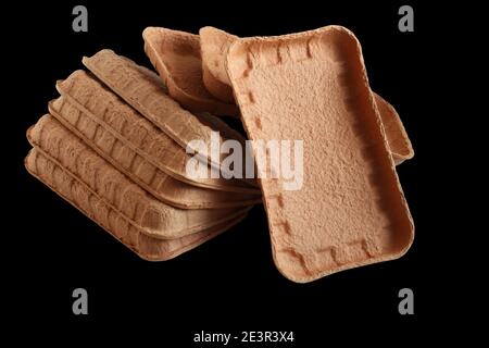 Biodegradable food trays made from pressed cardboard isolated on black background. Closeup Stock Photo