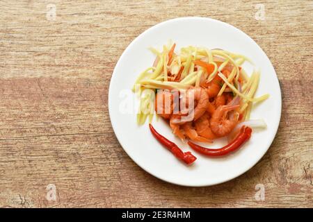 spicy dried shrimp with slice mango fruit salad on plate Stock Photo