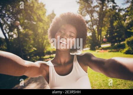 Photo portrait of shiny laughing woman shooting selfie in sunshine in park Stock Photo