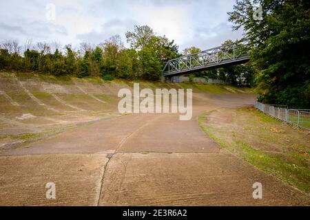 Brooklands racing circuit, view of the now mossy banked curve and foot bridge of this historic English racetrack / home of British motor racing Stock Photo
