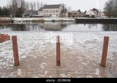 Anklam, Germany. 19th Jan, 2021. Flowers and candles stand at the scene of an accident in Anklam on the river Peene. A nine-year-old boy and a 43-year-old man died in a tragic slippery road accident. They had slid with their car on 13.01.2021 and fallen into a river. The fire brigade, which was alerted immediately, was unable to locate the sunken car in the five-metre-deep river Peene and thus could not help the car occupants. The driver was the partner of the mother of the boy who died. Credit: Stefan Sauer/dpa-Zentralbild/ZB/dpa/Alamy Live News Stock Photo