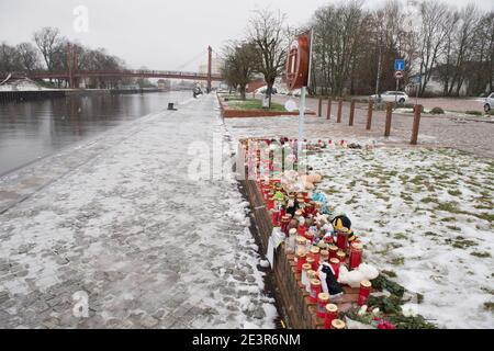 Anklam, Germany. 19th Jan, 2021. Flowers and candles stand at the scene of an accident in Anklam on the river Peene. A nine-year-old boy and a 43-year-old man died in a tragic slippery road accident. They had slid with their car on 13.01.2021 and fallen into a river. The fire brigade, which was alerted immediately, was unable to locate the sunken car in the five-metre-deep river Peene and thus could not help the car occupants. The driver was the partner of the mother of the boy who died. Credit: Stefan Sauer/dpa-Zentralbild/ZB/dpa/Alamy Live News Stock Photo