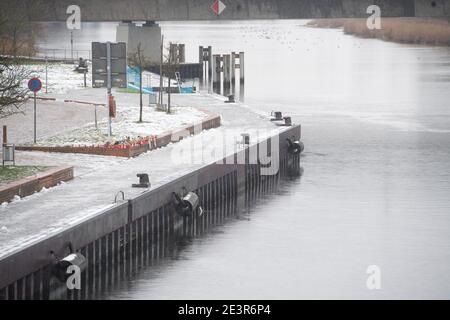 Anklam, Germany. 19th Jan, 2021. Flowers and candles stand at the scene of an accident in Anklam on the river Peene. A nine-year-old boy and a 43-year-old man died in a tragic slippery road accident. They had slid with their car on 13.01.2021 and fallen into a river. The fire brigade, which was alerted immediately, was unable to locate the sunken car in the five-metre-deep river Peene and thus could not help the car occupants. The driver was the partner of the mother of the boy who died. Credit: Stefan Sauer/dpa-Zentralbild/ZB/dpa/Alamy Live News Stock Photo