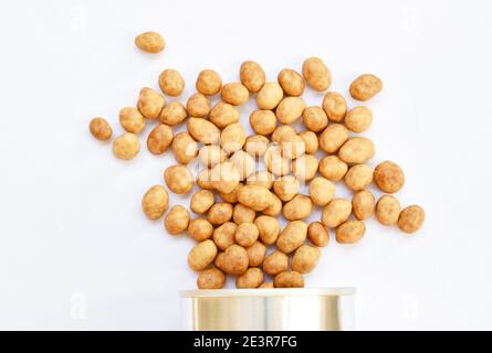 crispy sweet peanut coating coconut milk pouring from tin can packaging on white background Stock Photo