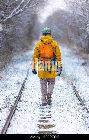 Rear view of man enjoying a walk through the woodland during winter Stock Photo