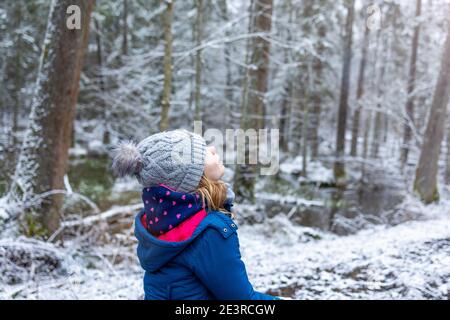 Little girl enjoying a walk through the woodland in winter, Bialowieza Forest, Poland Stock Photo