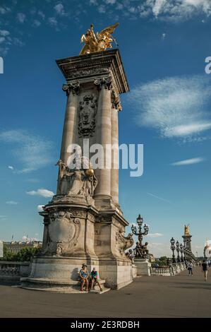 Paris, France - July 07, 2017. People sitting under monument at bridge from Paris. One of the most impressive world’s cultural center. France. Stock Photo