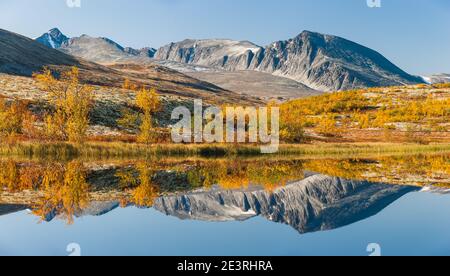 Mountains reflecting in lake in autumn. Rondane Nationalpark, Norway, Stock Photo