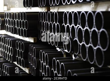 pipes of iron stacked in the warehouse on large wood pieces Stock Photo