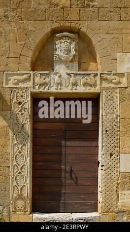 Ancient wooden doors with ornamental frame, Abbey of Sant'Antimo near Montalcino. High quality photo Stock Photo