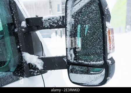 Snow in the rearview mirror of the car, drops on the glass. High quality photo Stock Photo