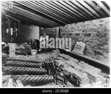 Man laying bricks inside building Stock Photo