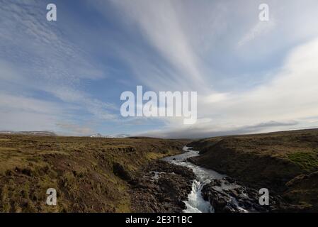 Stream flowing through lava field in Iceland Stock Photo