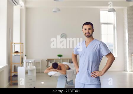 Young smiling confident man professional chiropractor masseur standing and looking at camera Stock Photo