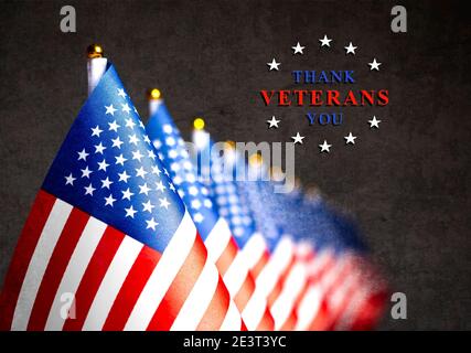 Several US flags and the inscription thank you veterans. Photo with a concrete wall texture. Memorial Day concept. Stock Photo