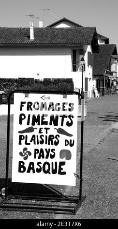 ESPELETTE, FRANCE - AVRIL 19, 2018: Sign pointing local delicatessen shop with traditional basque specialties. Black white historic photo Stock Photo