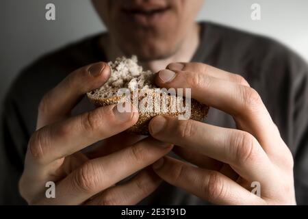 Hunger concept. Pieces of bread in the hands of a man. Poverty. Stock Photo