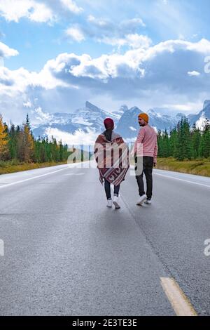 couple walking over The road 93 beautiful Icefield Parkway in Autumn Jasper National park,Canada. Canadian Rockies Stock Photo