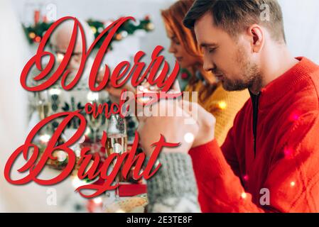 man praying with family while sitting at festive table, merry and bright illustration Stock Photo