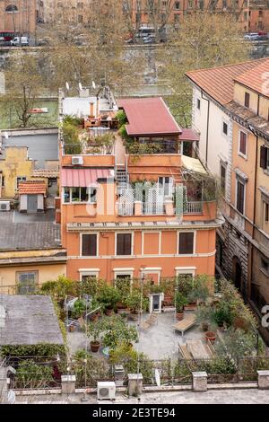 Aerial view looking down onto rooftops and roof garden terraces on the banks of the River Tiber in Trastevere, Rome, Italy, Stock Photo