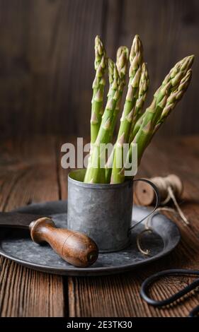 Nutritious vegetable high in antioxidants, a bunch of fresh green asparagus on rustic wooden background Stock Photo