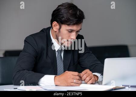 Unhappy young man, businessman feels stress at the office because of economic crisis and awful company loss. Business failure concept. Stock Photo