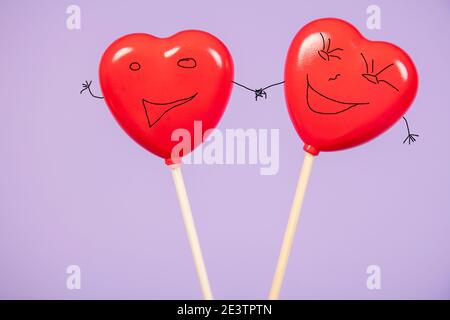 hearts with drawn cupcakes lie on a purple background, happiness in love concept Stock Photo