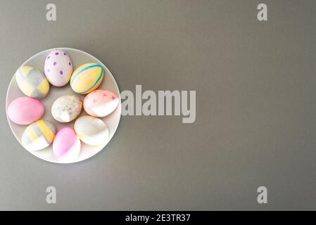 Easter eggs on a gray plate on a gray background with place for text. View from above. Stock Photo