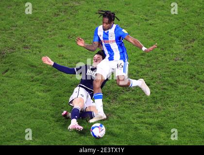 Millwall's Danny McNamara (left) slides in on Huddersfield Town's Rolando Aarons during the Sky Bet Championship match at The John Smith's Stadium, Huddersfield. Picture date: Wednesday January 20, 2021. Stock Photo