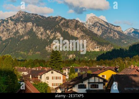 Small houses of Füssen in valley. Neuschwanstein castle on a rugged hill above the village of Hohenschwangau. Stock Photo