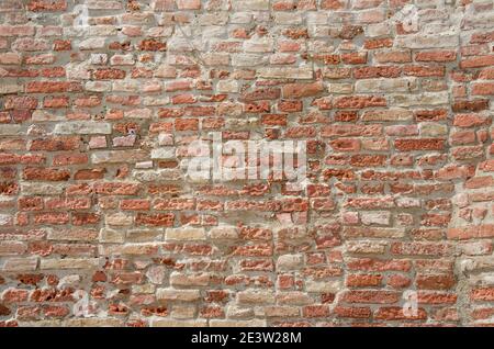 Old red grungy brick wall gives a harmonic structure Stock Photo
