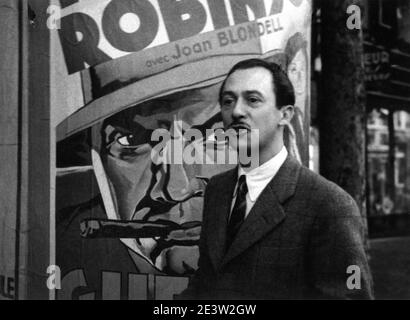 Candid Portrait of Swiss / French Hotelier and Fly Fishing Expert CHARLES RITZ by ANDRE DA MIANO taken in September 1936 in Paris next to a French Movie Poster of EDWARD G. ROBINSON and JOAN BLONDELL in BULLETS OR BALLOTS 1936 director WILLIAM KEIGHLEY Warner Bros. Stock Photo