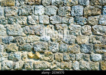 Fragment of a fortified wall made of stones and cemented with cement mortar Stock Photo