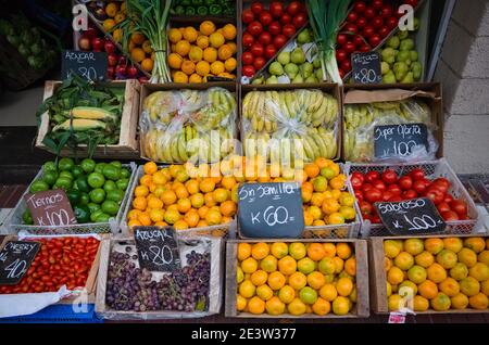 Market vendor with fruits and vegetables in boxes in small grocery shop along the street. Mar del Plata, Argentina Stock Photo