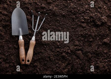 Garden tools on fertile soil background, copy space Stock Photo