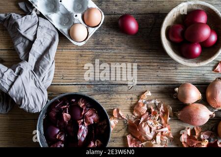 Dyed Easter eggs painted with natural dye onion on wooden background. Process of dyeing eggs with natural paints for Easter. Natural ecological staini Stock Photo