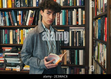 young man holding book in bookshop Stock Photo