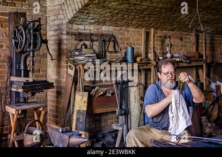 Blacksmith Ralph Oalmann polishes a spatula he recently made in his shop at Fort Gaines, Aug. 5, 2017, in Dauphin Island, Alabama. Stock Photo