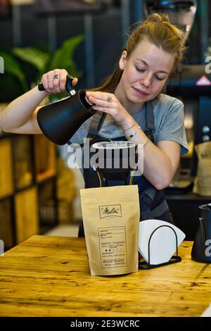 female barista pouring coffee through melitta filter Stock Photo